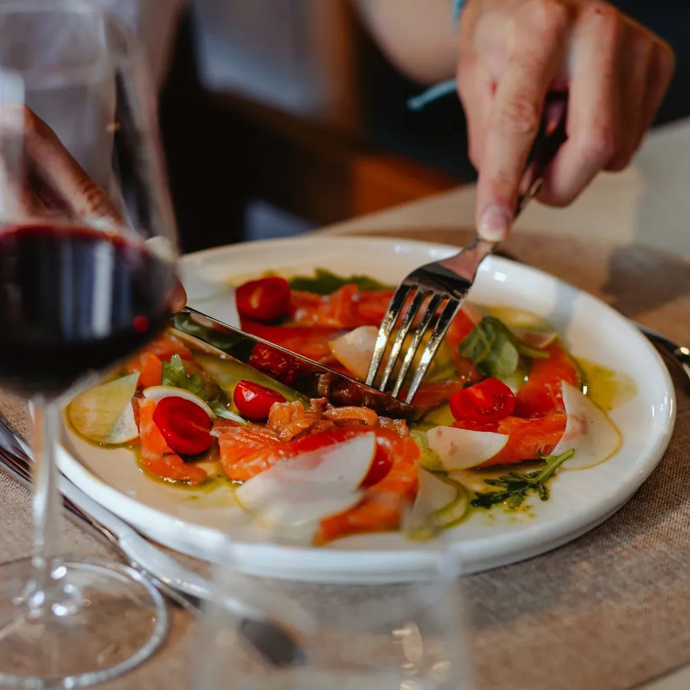 Salata sa lososom i čeri paradajzom, uz čašu crnog vina